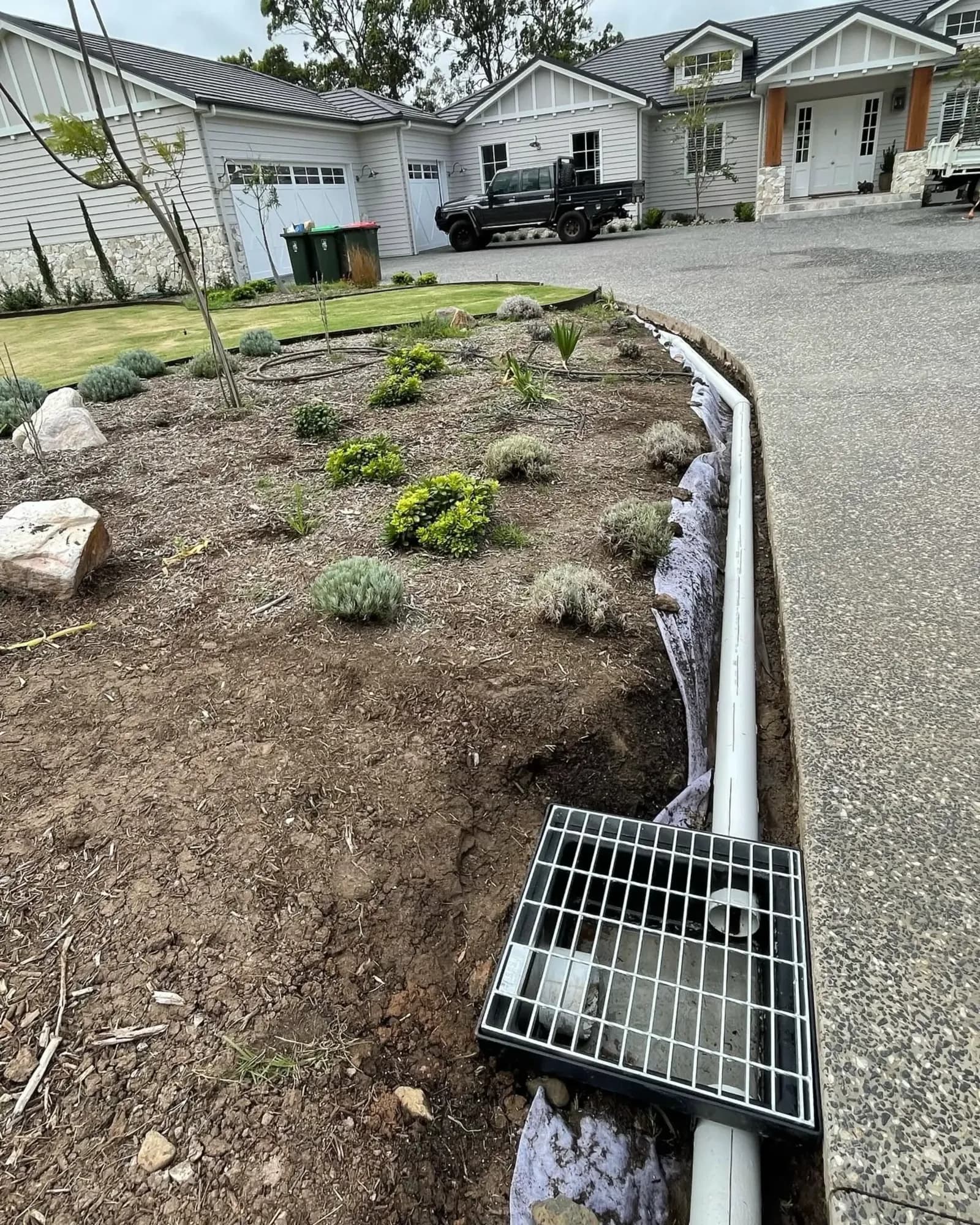 Grated stormwater drain along a garden bed