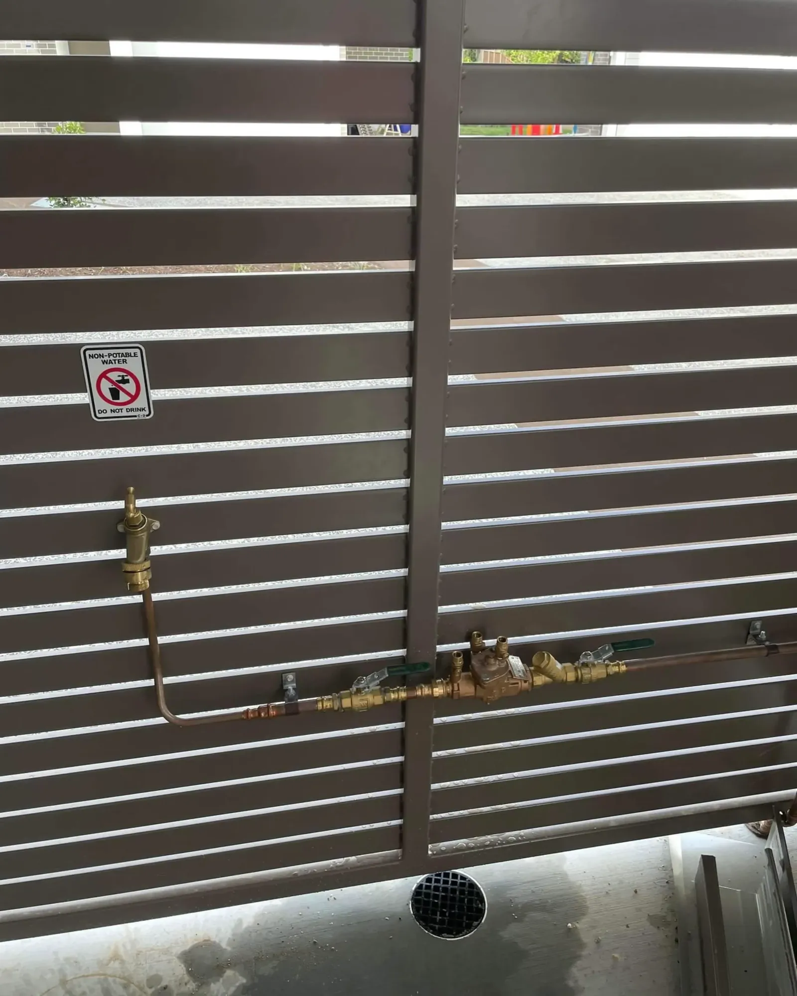 Garden tap installed on a slatted fence