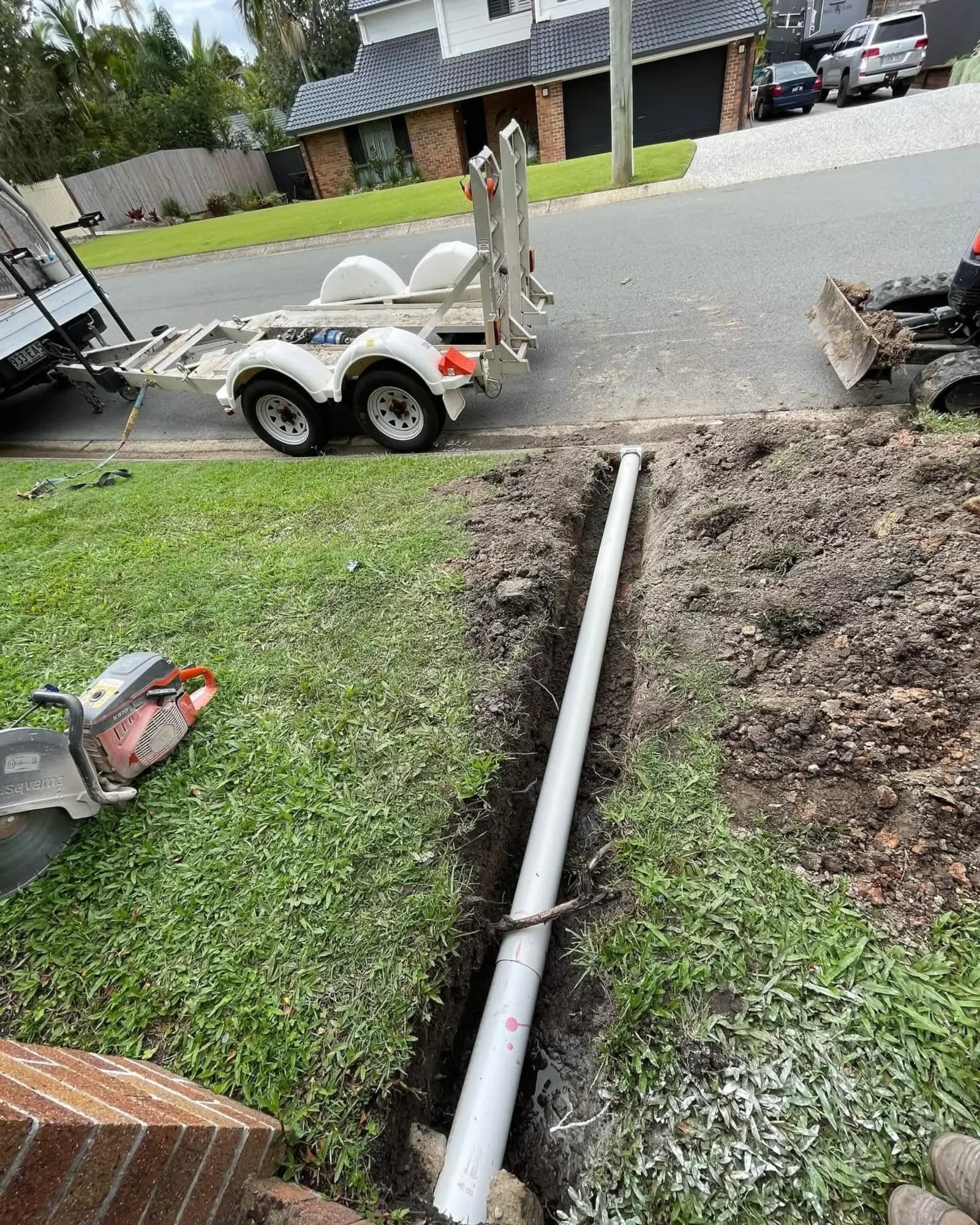 Trench cut across a front lawn to replace a water pipe