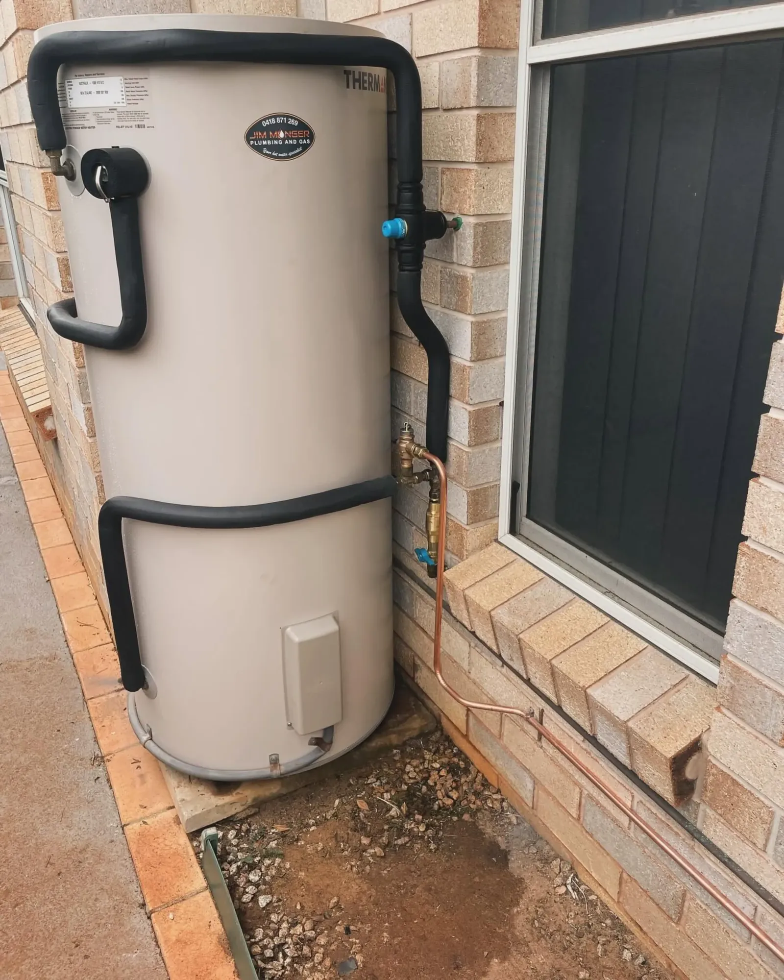 Electric hot water storage tank installed beside a window