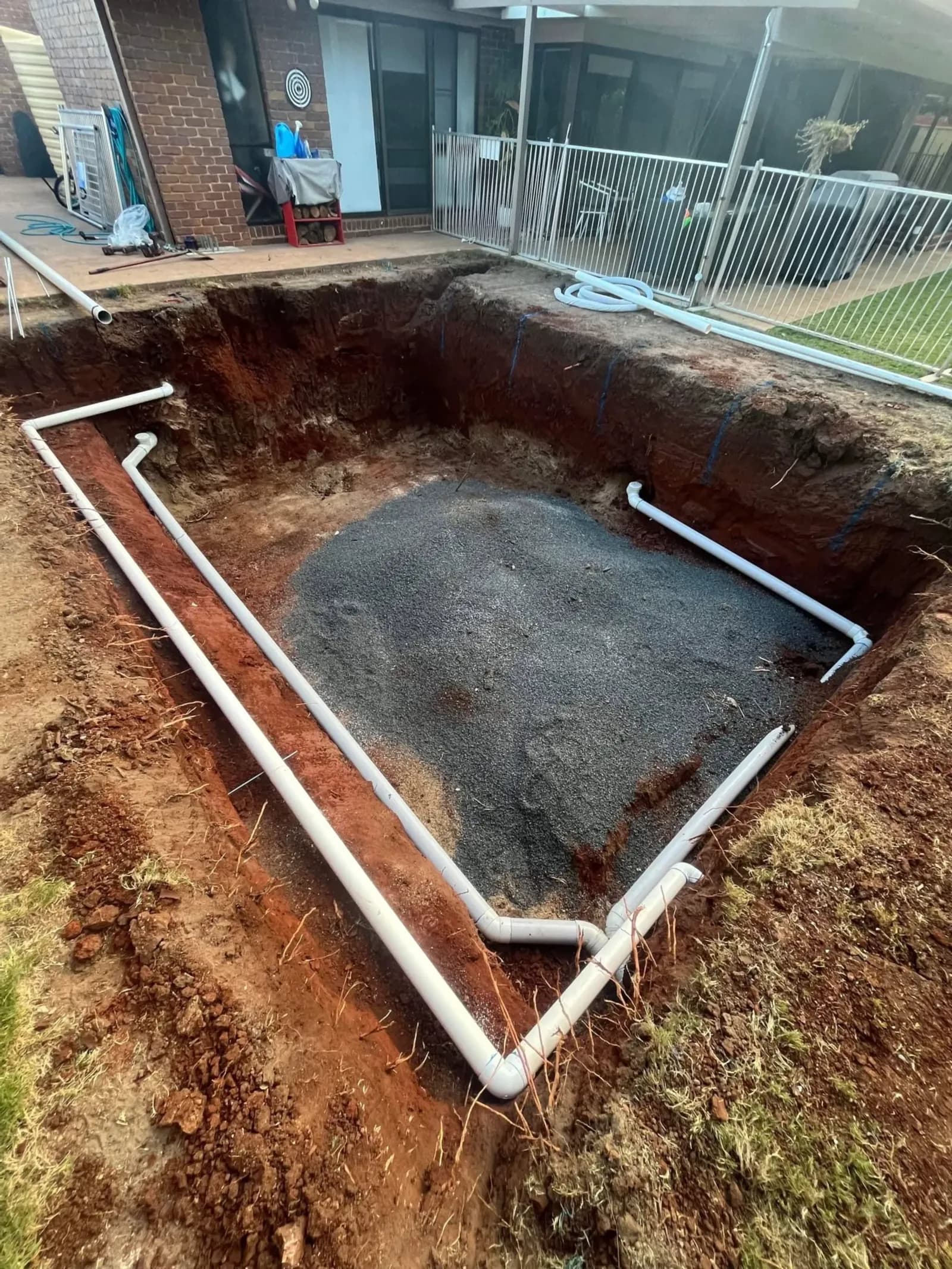 New drain pipes laid around a pit at a large block