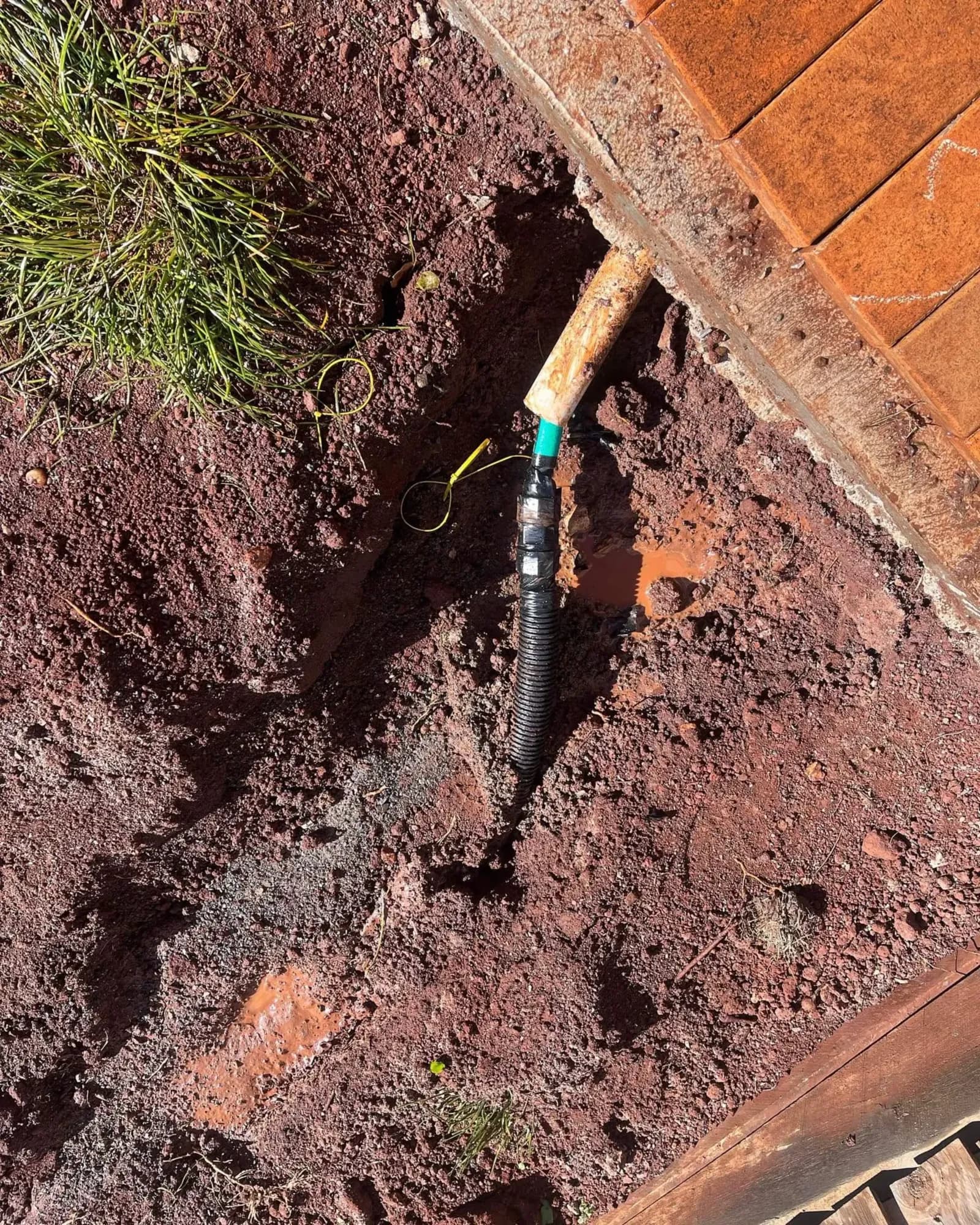 Water pipe uncovered in a dug-out hole for a leak repair