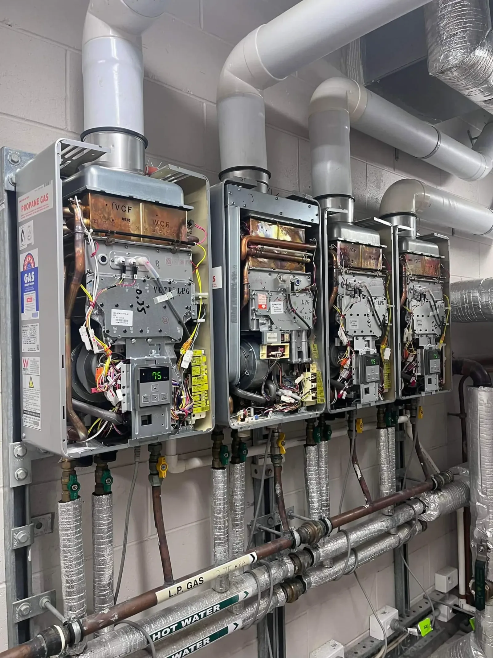 Bank of continuous flow gas water heaters being serviced
