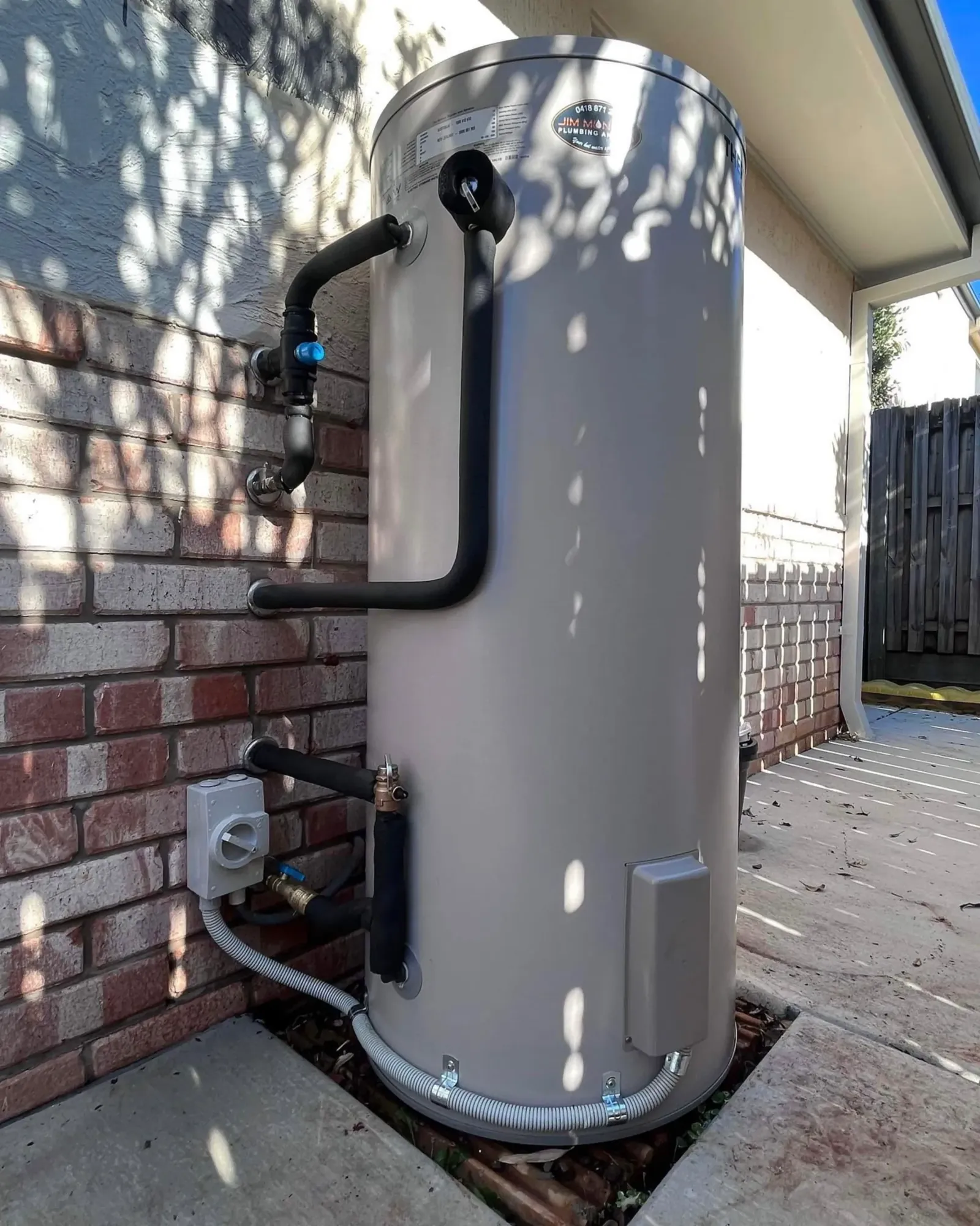 Electric hot water system installed beside a brick wall