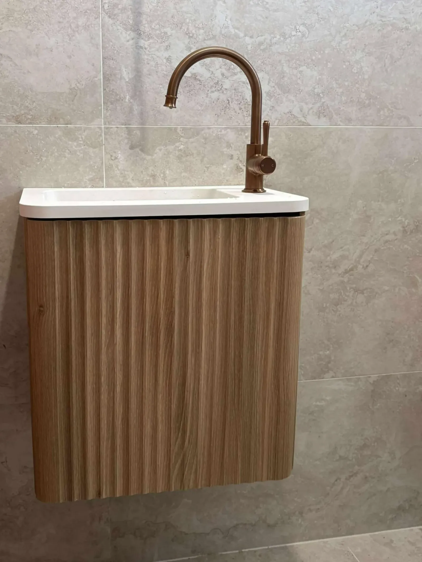 Wall-hung vanity with a brass mixer tap