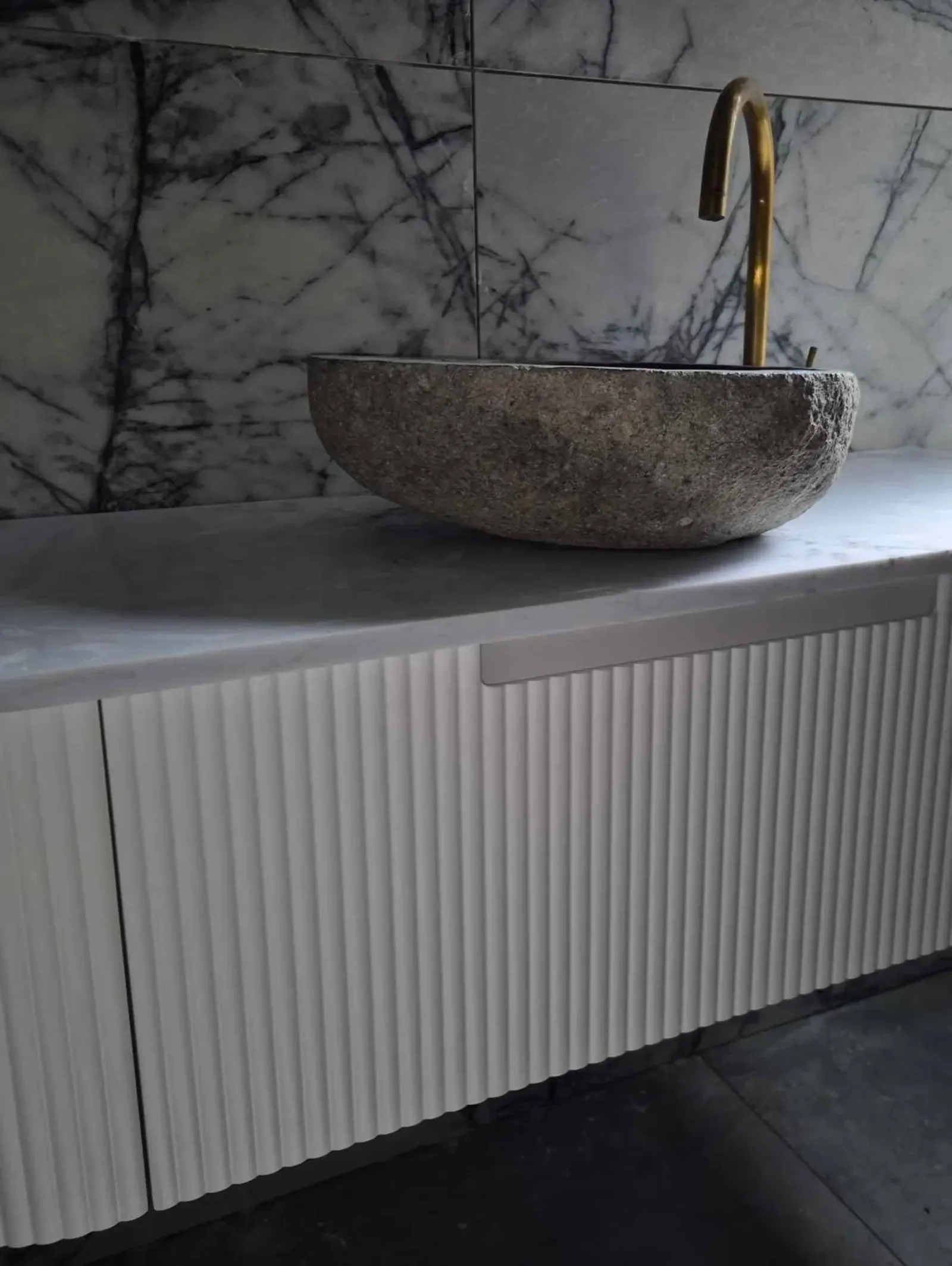 Stone vessel basin and wall tap in a renovated bathroom