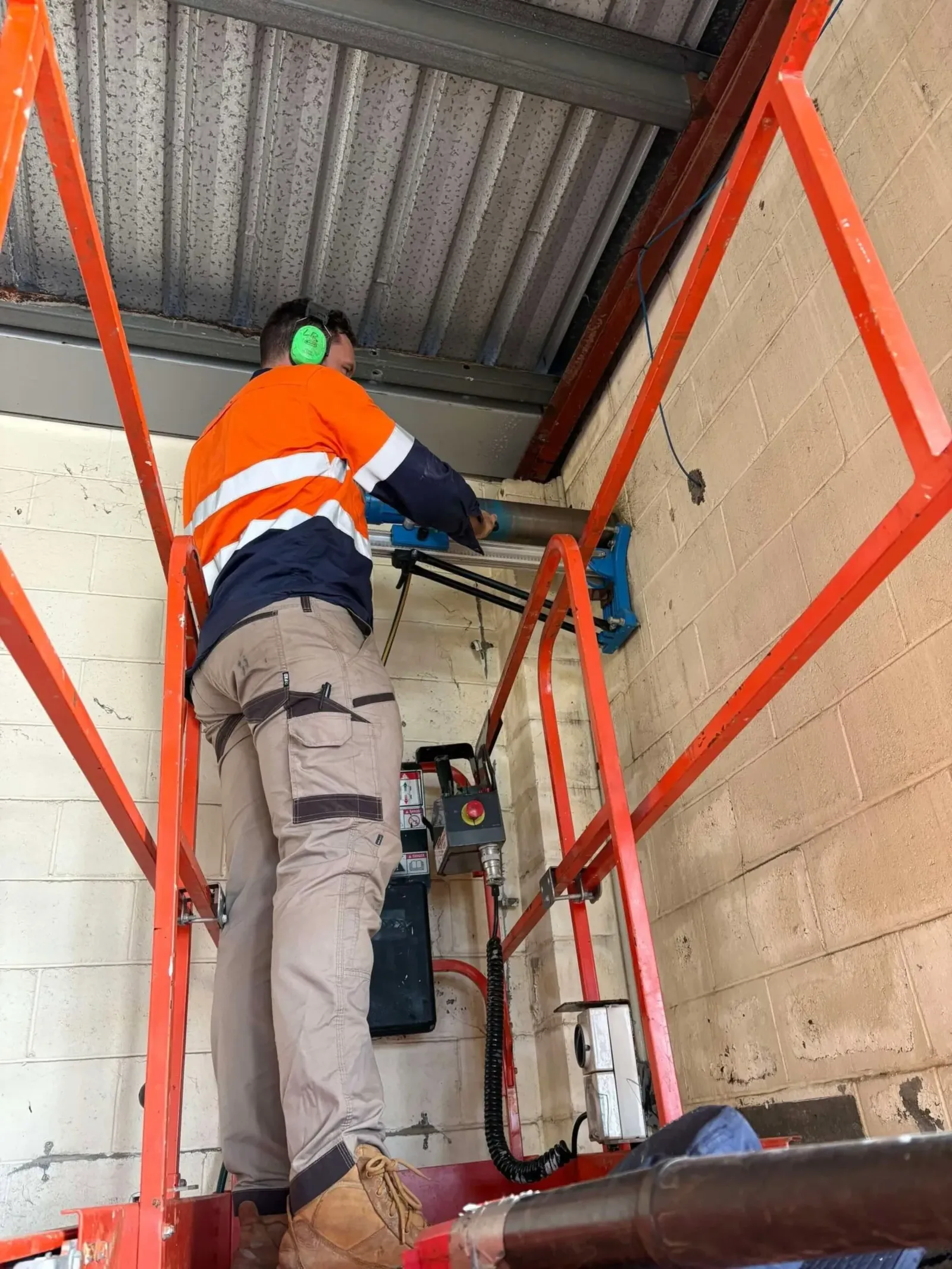 Plumber working from a scaffold on a building site