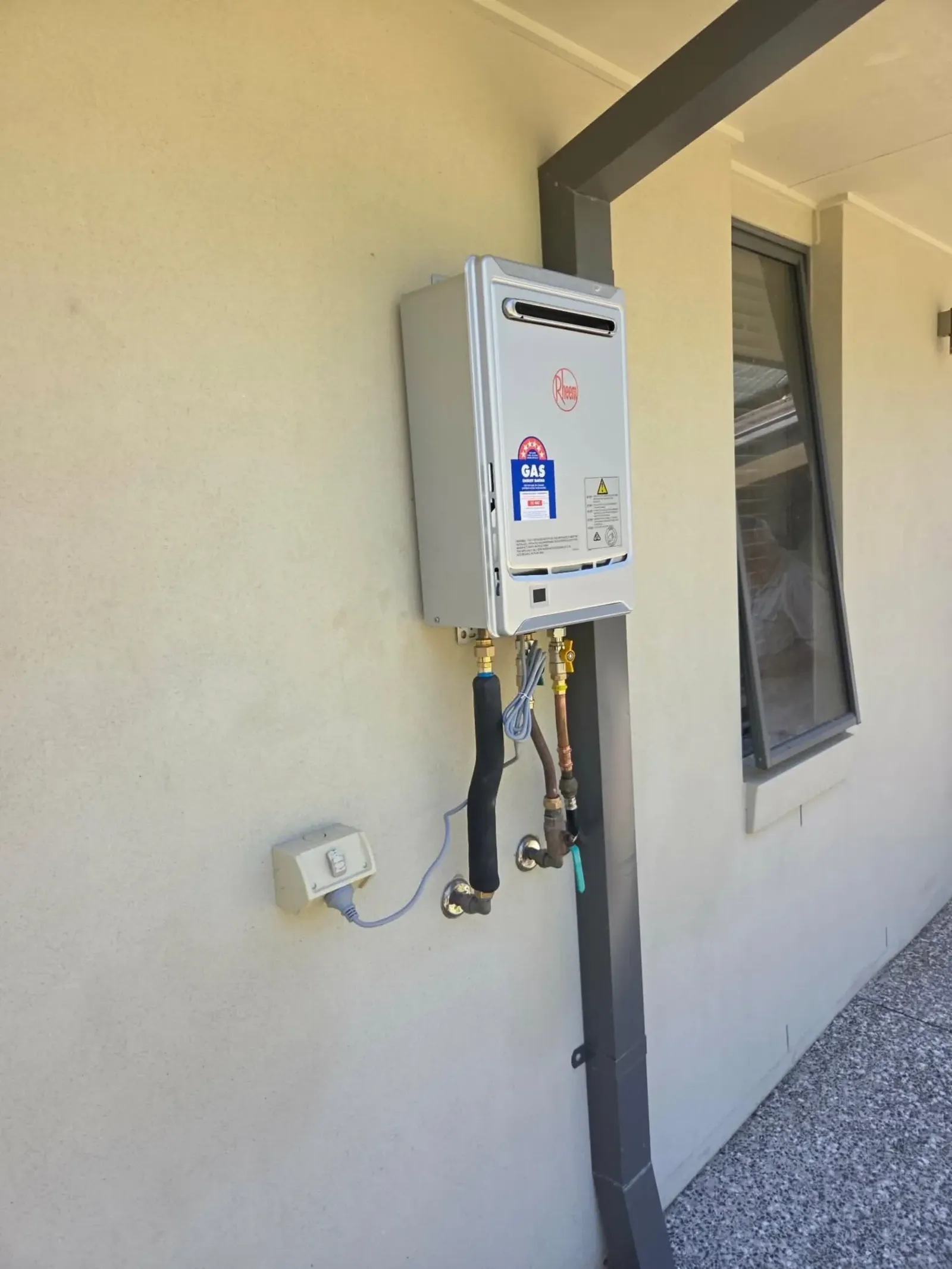 Gas continuous flow water heater installed on an outside wall