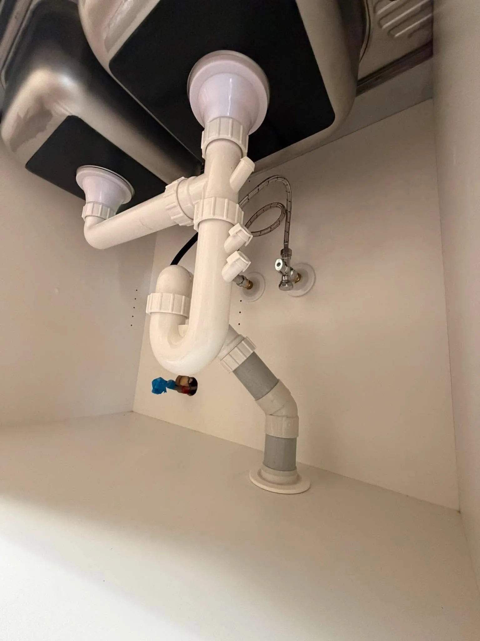 New PVC waste trap and drain fitted under a sink