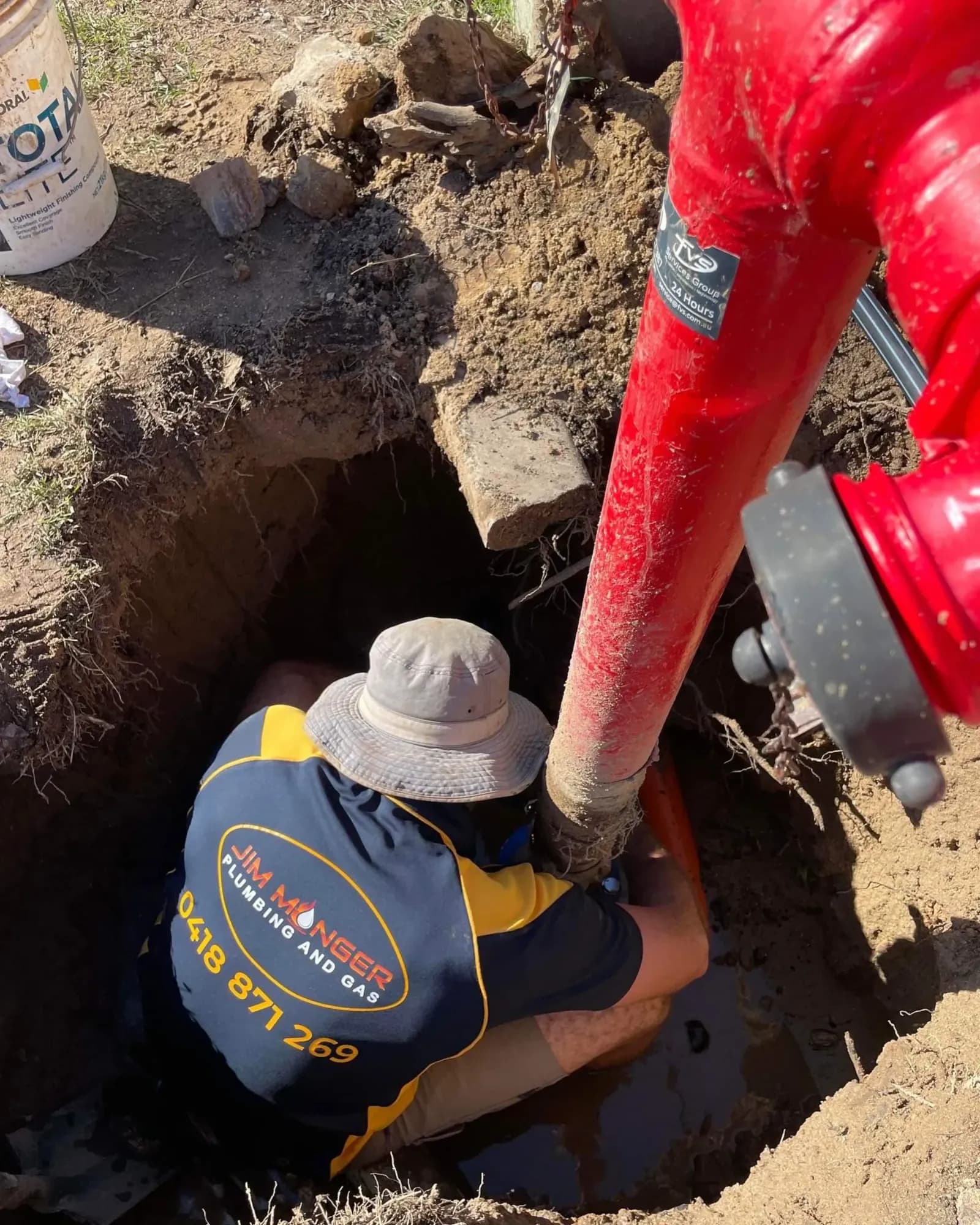 Jim Monger plumber working on an underground hydrant connection